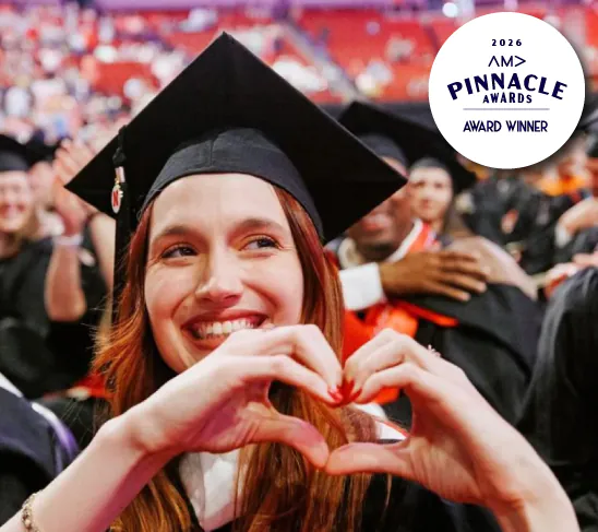 Smiling Nebraska Law graduate making a heart shape with her hands